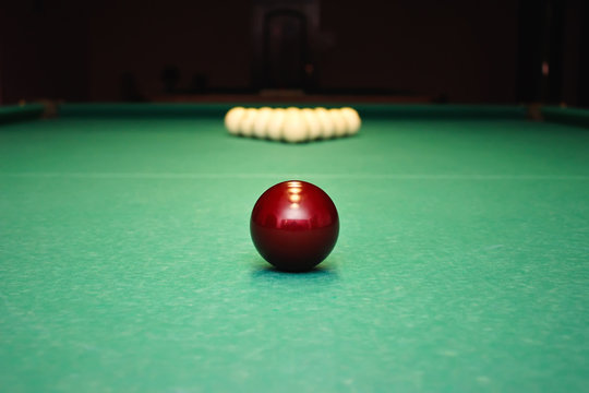 Closeup shot of red ball going in billiard pocket