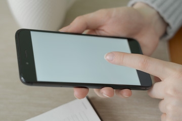 A girl searches for information on the Internet using a smartphone