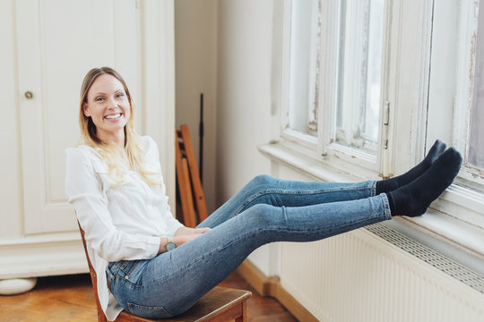 Smiling young woman relaxing with feet up