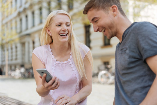 Laughing couple looking at data on a mobile