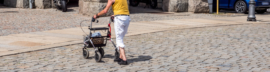 Panorama Alte Frau mit einem Rollator überquert die Straße