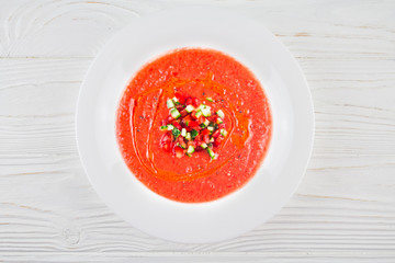 Spanish gazpacho soup with a toast on a wooden background