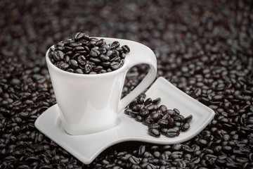 white cup of coffee with coffee beans on a textured sack background with lights and shadows