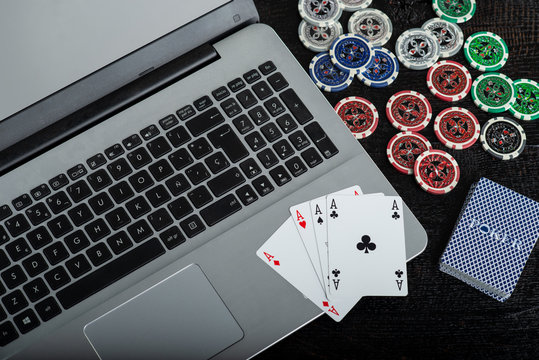 online poker with laptop and chips. 4 poker aces advertising image