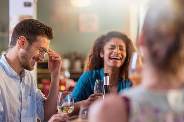 Mixed group of friends having fun while sharing a meal 