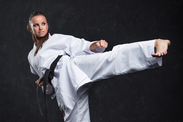  A girl in a white kimono with a black belt on a dark background