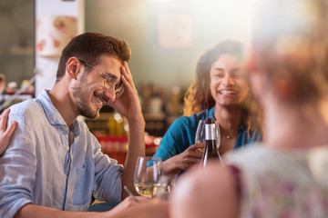 Mixed group of friends having fun while sharing a meal 