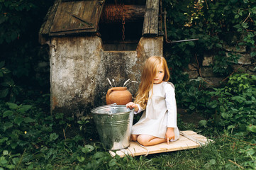 little girl with white hair at the well on a green background