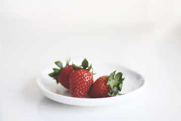 Erdbeeren in einer weissen Schale vor weißem Hintergrund