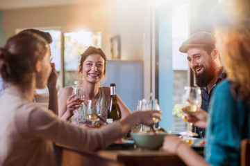 Mixed group of friends having fun while sharing a meal 