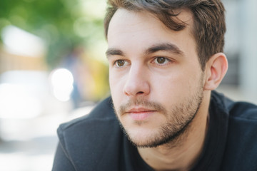 Obraz premium An attractive and handsome man with stylish hair and beard, interesting funny story. Portrait of a worried young man at the workplace. Stress concept.