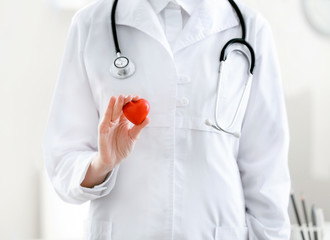 Female doctor with red heart in office