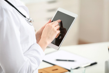 Obraz na płótnie Canvas Female doctor with tablet PC in office