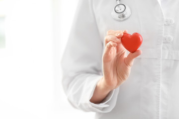 Female doctor with red heart on blurred background