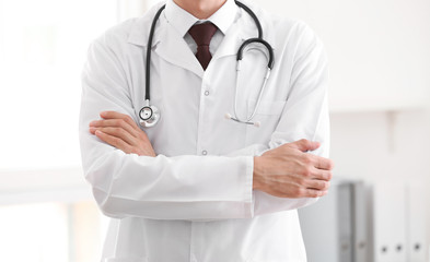 Male doctor with stethoscope in office