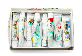 Tubes with color paints in box on white background