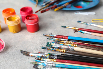 Obraz premium Brushes and jars with paints on table