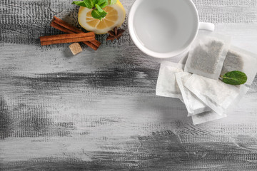 Cup with water and tea bags on wooden table