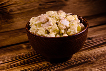 Salad with the haricot beans and meat dressed with mayonnaise in ceramic bowl