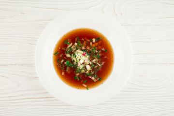 Russian cold soup - okroshka with kvass, on a wooden background