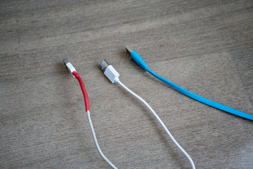 USB cables in white and blue on wooden floor