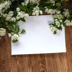 Summer composition from blossoming apple tree branches against the background of natural wood and accessories