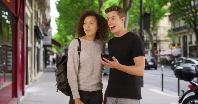 Multiethnic male and female use cellphone for directions in Paris, Two millennials lost on Paris streets use map on mobile phone, 4k