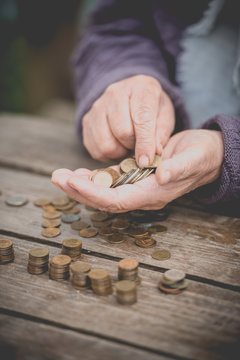  Money, coins, the grandmother on pension and the concept of life, minimum - the old grandmother sadly collects small coins on a wooden table