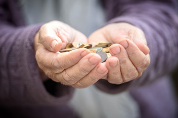 Money, coins, the grandmother on pension and the concept of life, minimum - in hands old a handful of coins. Close up