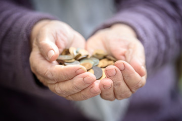 Money, coins, the grandmother on pension and the concept of life, minimum - in hands old a handful of coins. Close up