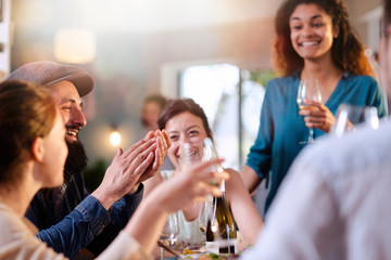 Mixed group of friends having fun while sharing a meal 