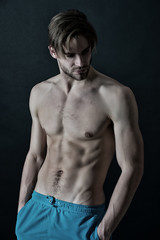 Sportsman with sexy torso and chest. Training and workout activity in gym. Man with six pack and ab...