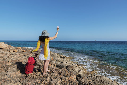 Caucasian woman waving on a coast in Majorca