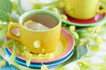Cups of herbal tea with linden blossoms and lemon