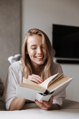 Happy young woman reading blank cover open book