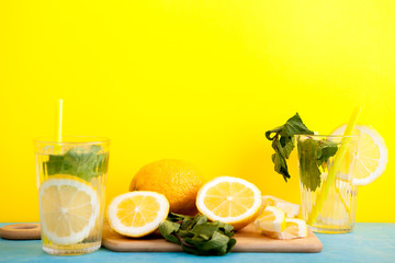 Tasty and organic detox water with lemons over yellow background in studio photo