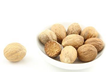 nutmeg seeds in a small white bowl