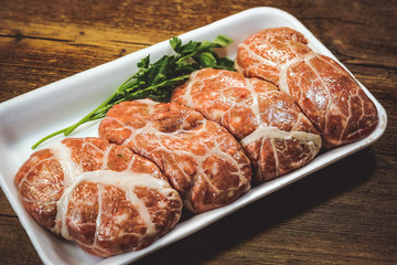 raw cutlets in a package on a wooden background