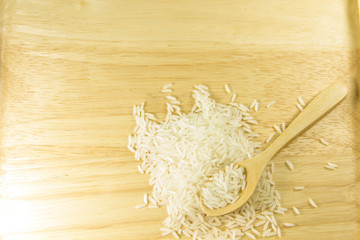 Rice and wooden spoon on wooden table