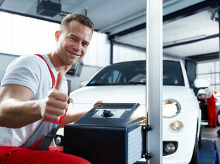 Car mechanic testing light of car in garage