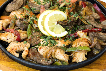 Bulgarian traditional cuisine. Sach of mixed meats and vegetables on wooden background. Macro, close up