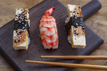 sushi on a wooden board, chopsticks for sushi, close-up