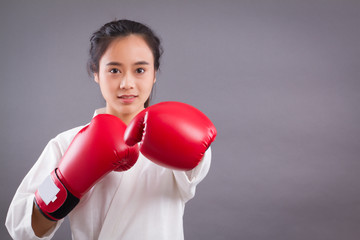 woman fighter portrait; asian woman practicing martial arts, mixed martial arts, MMA, karate, gongfu studio isolated portrait; girl fighter training concept; 20s young adult asian woman model