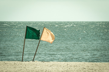 Lifeguard Flags on a windy day at the beach - Faded Retro Film Look