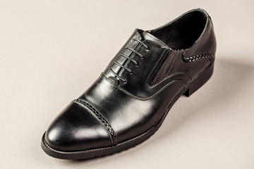 Black men shoes against gray background