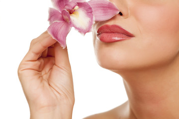 beautiful young woman smells orchid on white background