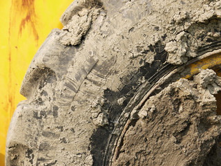 close up of tire bulldozer, yellow and covered with mud