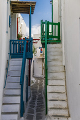 Mykonos, Greece whitewashed alleys. Traditional dotted narrow alleys with painted balconies and white stairs at Mykonos Town (Chora).