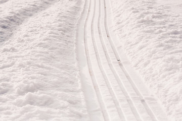 Fototapeta na wymiar Trail of sledges on the snowy slope of the mountain, winter snow frosty weather