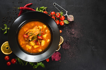 Hungarian soup bograch on black background. Top view